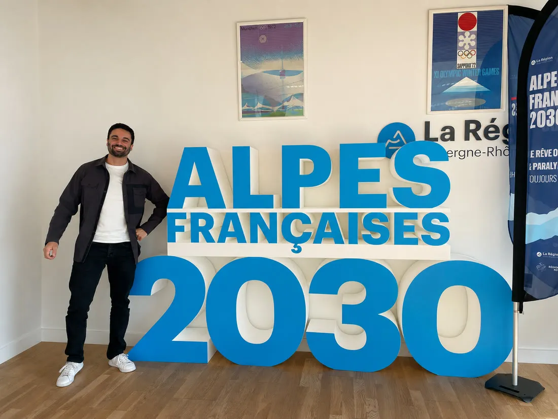 Nathan devant le sigle Alpes Françaises 2030 (candidature olympique)